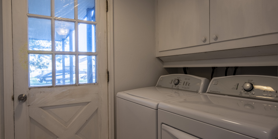 Laundry room with door to the left & machines to the right.